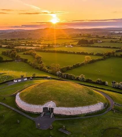 The Newgrange mound beneath a warm sky